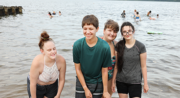 Four blind teems smile together in a lake during and NFB STEM2U program.